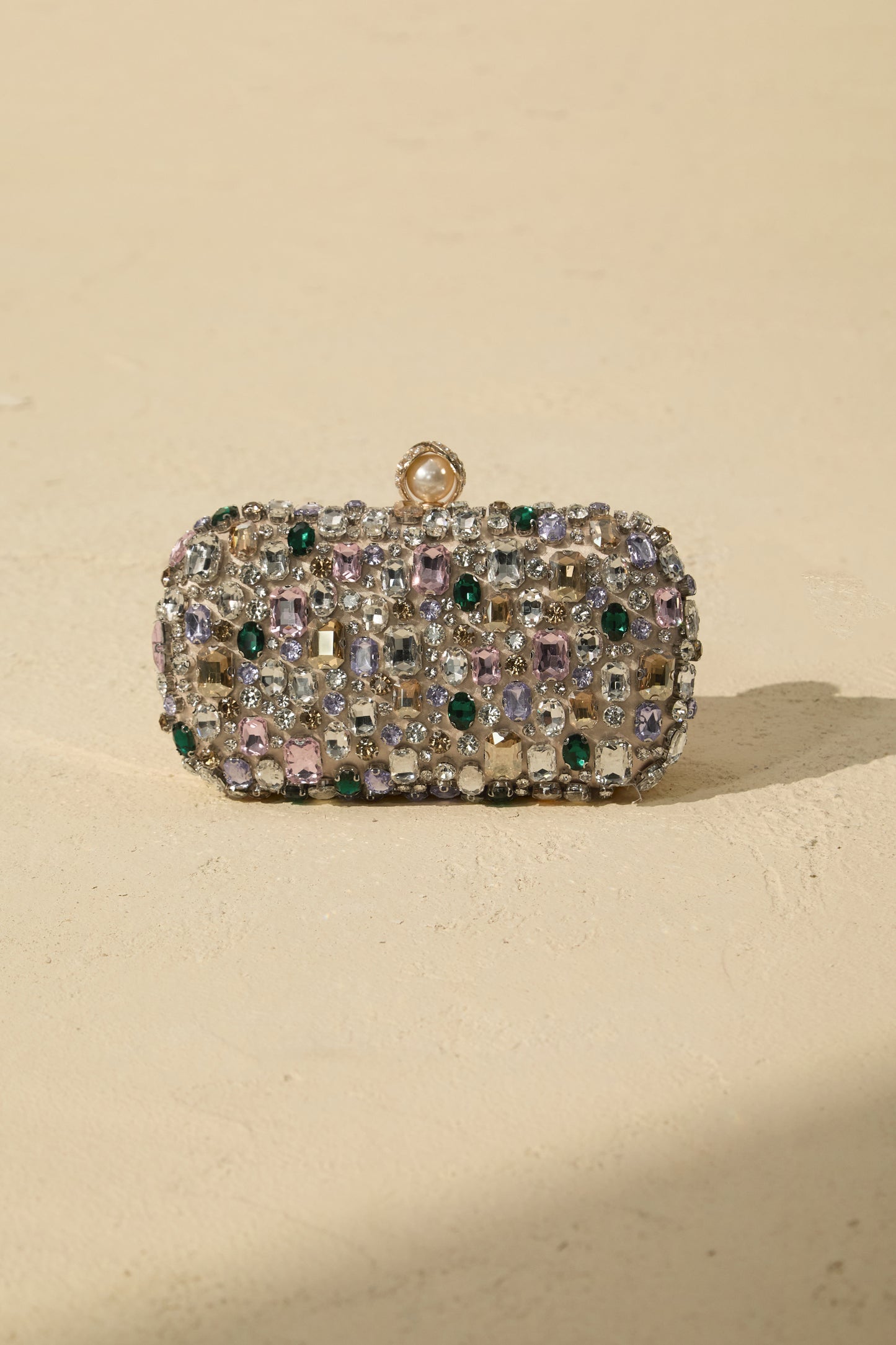 Clutch de satén con cristales, en mano
