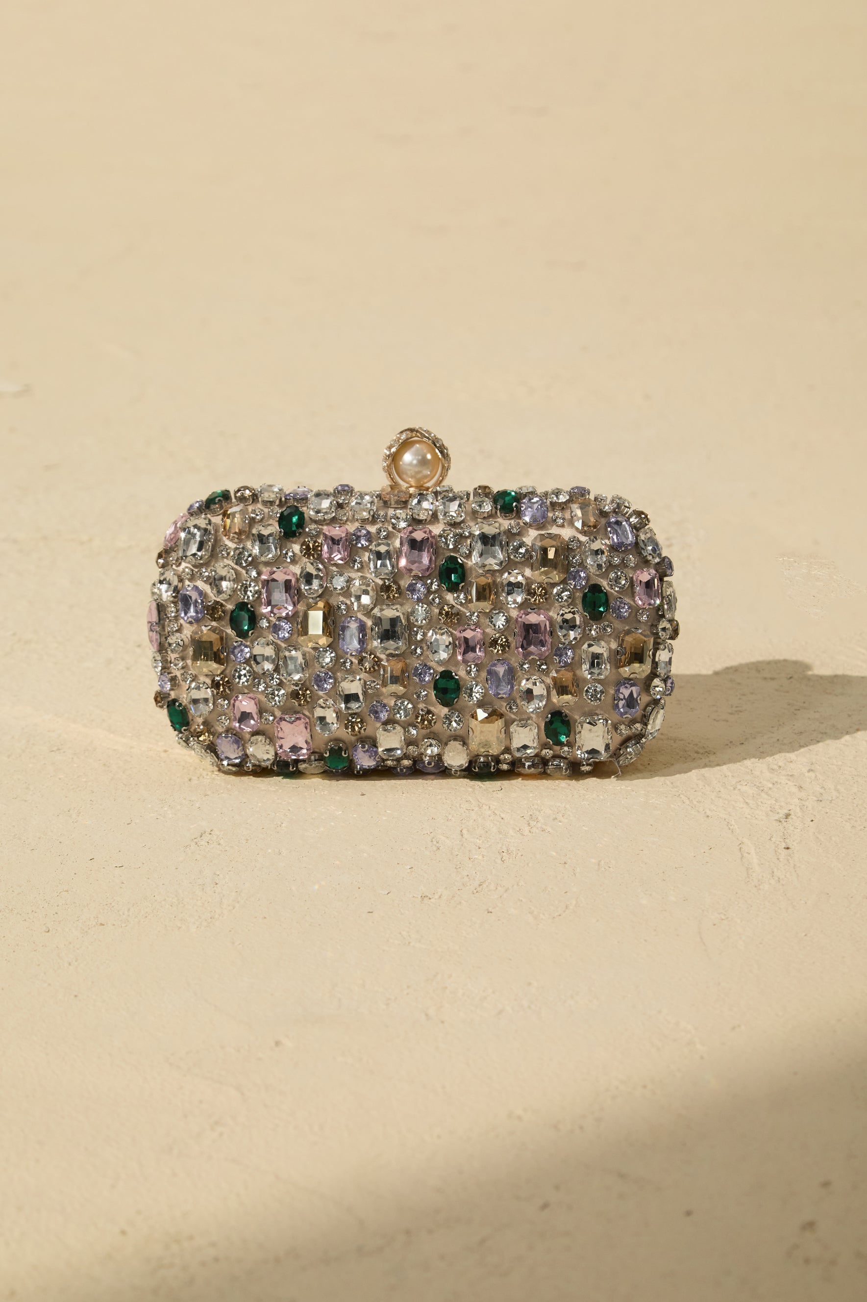 Clutch de satén con cristales, en mano