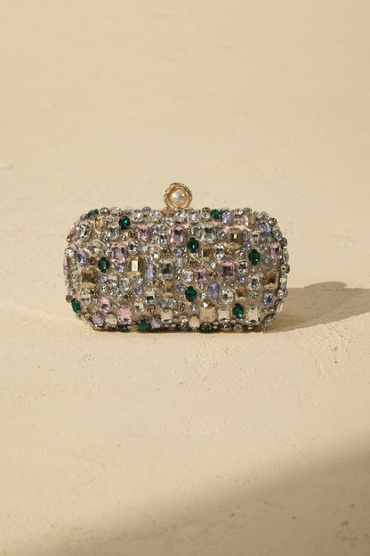 Clutch de satén con cristales, en mano
